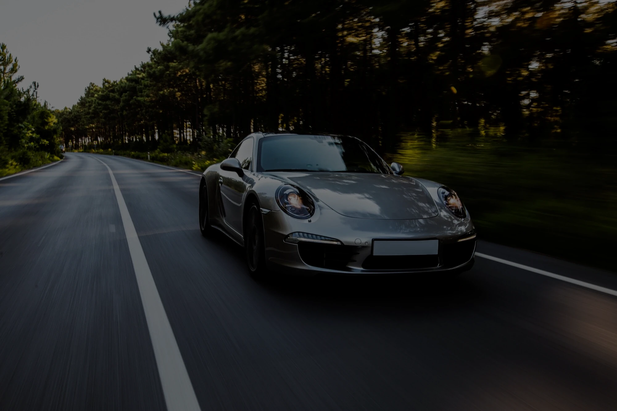 A Porsche driving down a country road